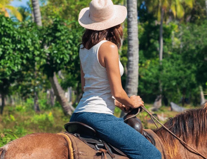 Woman horseback riding in the jungle