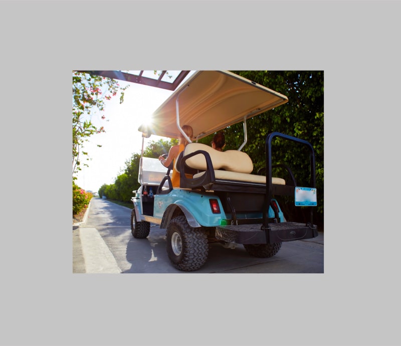Riding in golf cart at Mahogany Bay Resort & Beach Club