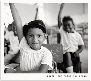 Young Belizean Girl raising her hand in a classroom